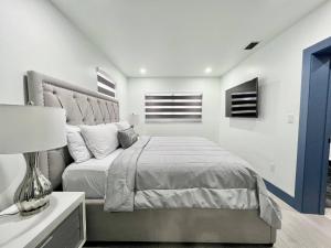 a bedroom with a bed and a table with a lamp at Renovated Villa resort pool, BBQ and Ping Pong Patio in Tamiami +38 photos