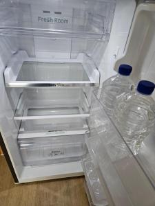 an empty refrigerator with two water bottles in it at Ssuny house in Seoul