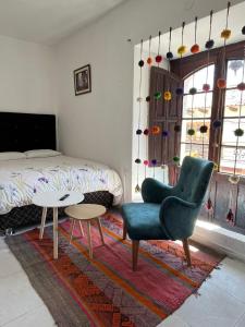 sypialnia z łóżkiem, krzesłem i stołem w obiekcie Qosqollay Plaza de armas w Cuzco