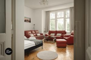 uma sala de estar com mobiliário de couro vermelho e um sofá em Central Apartments Pařížská em Praga
