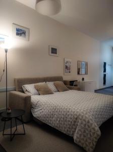 een slaapkamer met een bed en een bank bij LF_SUITE_ Lugano Lake_ Ampia Terrazza ; Spiaggia privata_ WI-FI_ Netflix_ in Porlezza