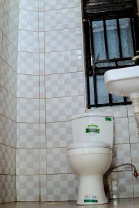 y baño con aseo y lavamanos. en EQUATOR GATES HOTEL, en Bulenga