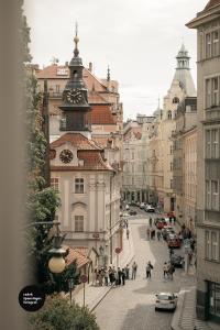 uma rua da cidade com um edifício com uma torre de relógio em Central Apartments Pařížská em Praga