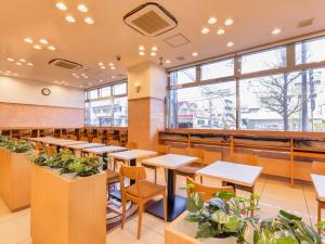 大崎市APA Hotel Miyagi Furukawa Ekimae的摆放着桌椅和盆栽的餐厅