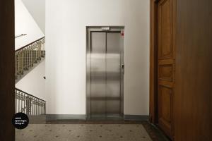 um elevador de metal num edifício com uma escada em Central Apartments Pařížská em Praga