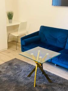 un divano blu e un tavolo in vetro in soggiorno di Roomello luxury City Studios a Peterborough