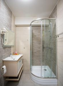 uma casa de banho com um chuveiro e um lavatório. em Meridien Home Apartment em Fonyód