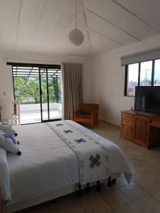 a bedroom with a bed and a flat screen tv at Hotel Ocho Barrios in San Cristóbal de Las Casas