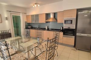 eine Küche mit einem Glastisch mit Stühlen darin in der Unterkunft SUNNY Apartment - SAL VILA VERDE - Cabo Verde in Santa Maria