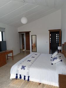 um quarto com uma grande cama branca num quarto em Hotel Ocho Barrios em San Cristóbal de Las Casas