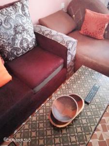 a living room with a couch and a bowl on a table at Backpackers at Banana Hill in Nairobi