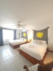 a bedroom with two beds and a ceiling fan at Villa Boscardi in Belize City