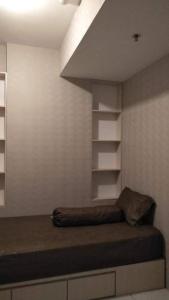 a room with a bed and shelves in a room at Apt m34 square by kiiw in Bandung