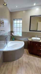 a large bathroom with a large tub and a sink at Wapadrand Guest Suite in Pretoria