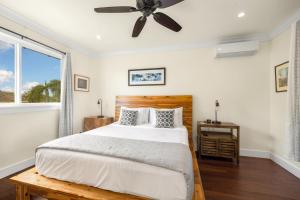 a bedroom with a bed and a ceiling fan at Kolepa Kai in Koloa