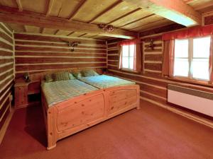 a bedroom with a bed in a log cabin at Chaloupka Pod Kopřivnou in Malá Morávka
