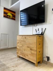 una TV a schermo piatto sopra un comò in legno di Living Genova Apartment a Genova