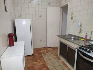 een keuken met een witte koelkast en een wastafel bij CASA de vila 2 Qts Perto estação in Rio de Janeiro