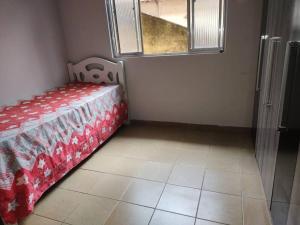 een slaapkamer met een bed, een raam en een tegelvloer bij CASA de vila 2 Qts Perto estação in Rio de Janeiro