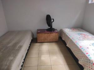 een kamer met 2 bedden en een mand op de vloer bij CASA de vila 2 Qts Perto estação in Rio de Janeiro
