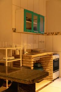 cocina con armarios verdes y encimera en Pituba Ville - Ap 1 - 2 Quartos, en Itacaré