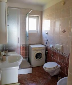 a bathroom with a washing machine and a washer at Apartments by the sea Njivice, Krk - 5295 in Njivice