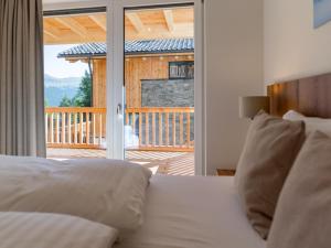 - une chambre avec un lit et une vue sur une terrasse dans l'établissement Atemlos Mountain Chalet, à Turracher Höhe