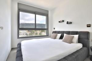 a bedroom with a large bed and a window at Luxury apartment on the beach in Haifa