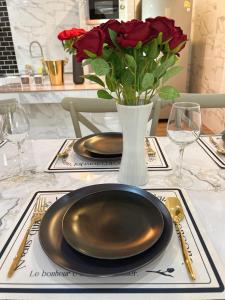 a table with two plates and a vase with roses at Love House in Ban Zong Katiam