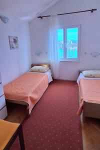 1 Schlafzimmer mit 2 Betten und einem Fenster in der Unterkunft Apartments by the sea Rogoznica - 7499 in Rogoznica