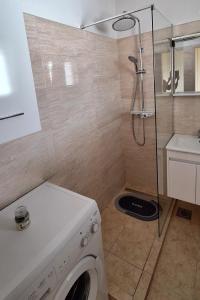 eine Waschmaschine im Bad mit Dusche in der Unterkunft Apartments by the sea Rogoznica - 7499 in Rogoznica