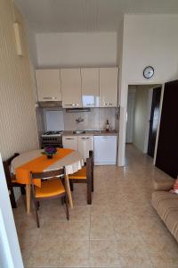 eine Küche und ein Esszimmer mit einem Tisch und Stühlen in der Unterkunft Apartments by the sea Rogoznica - 7499 in Rogoznica