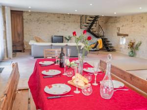 una mesa con mantel rojo y copas de vino en La grande Grange en Loubejac