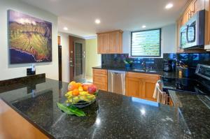 a kitchen with a bowl of fruit on a counter at Poipu Shores 101A in Koloa