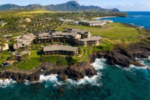 an aerial view of a house on a rocky island in the ocean at Makahuena 1204 Ocean View in Koloa