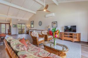 uma sala de estar com um sofá e uma televisão em Nihi Kai 203 Poipu Poolside em Kipu