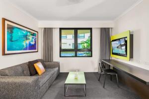 a living room with a couch and a tv at Contemporary 1-Bed First Floor Unit with Pool in Sydney