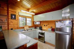 a kitchen with stainless steel appliances and wooden walls at 20 Bristol Street in Hanmer Springs