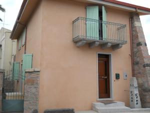 a building with two balconies and a door at Bed & Breakfast S'Ena in Pozzomaggiore