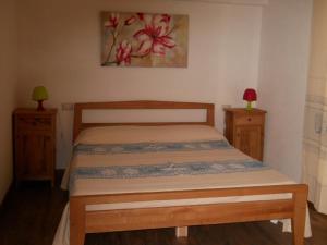 a bedroom with a bed with two night stands and a painting at Bed & Breakfast S'Ena in Pozzomaggiore