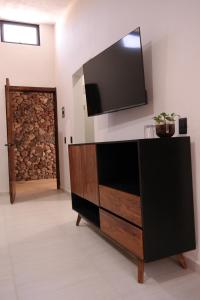 ein Wohnzimmer mit einer Kommode und einem Fernseher an der Wand in der Unterkunft Quinta Pichón in Tepic