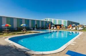 a large swimming pool in front of a building at Caravan at Seawick Holiday Park Close to Beach in Saint Osyth