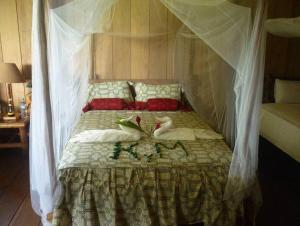 Una cama con mosquitera encima. en Tahuayo Lodge Expeditions en Iquitos