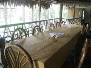 a large wooden table with chairs and a large window at Tahuayo Lodge Expeditions in Iquitos