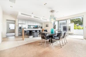 een eetkamer en een keuken met een tafel en stoelen bij Sentinel Beach House - Auckland Holiday Retreat in Auckland