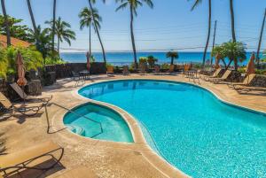 una piscina con sedie e l'oceano sullo sfondo di Nihi Kai 802 - Ocean Views a Kipu
