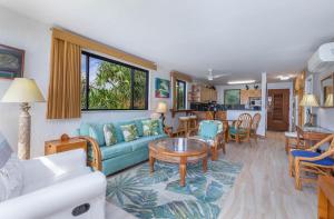 a living room with a blue couch and a table at Poipu Shores 207A in Koloa