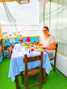 Ein Mann, der an einem Tisch mit einem Tischtuch sitzt. in der Unterkunft HOSPEDAJE WELCOME paracas in Paracas