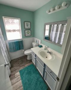 een badkamer met een wastafel, een toilet en een spiegel bij 3 bedrooms house with private, heated pool 8 miles to Siesta Key Beach, in Sarasota