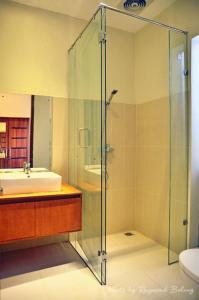 a bathroom with a glass shower and a sink at Oxy House Bali in Sanur